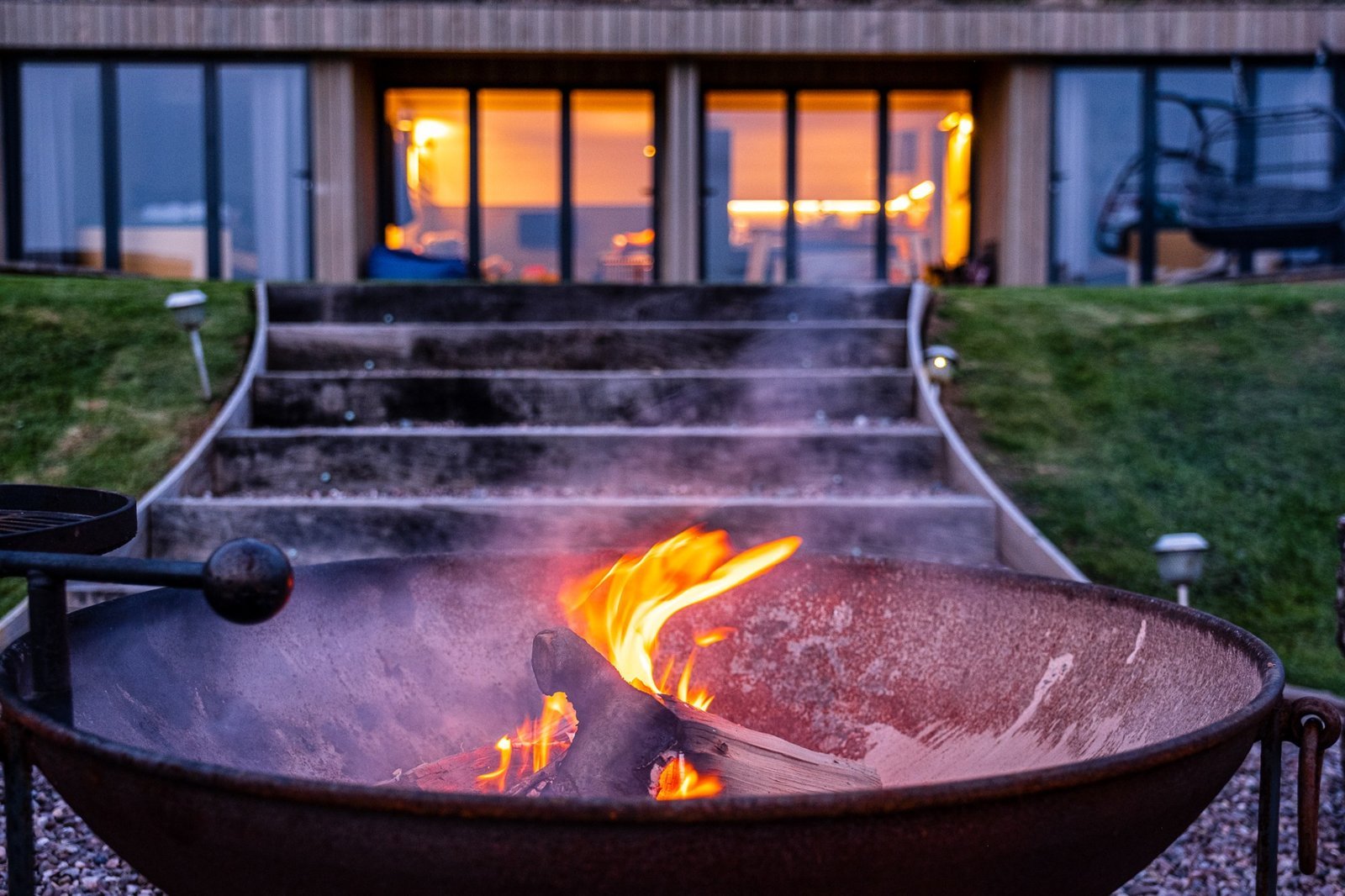 Firepit burning outside a Pontypinna lodge at dusk