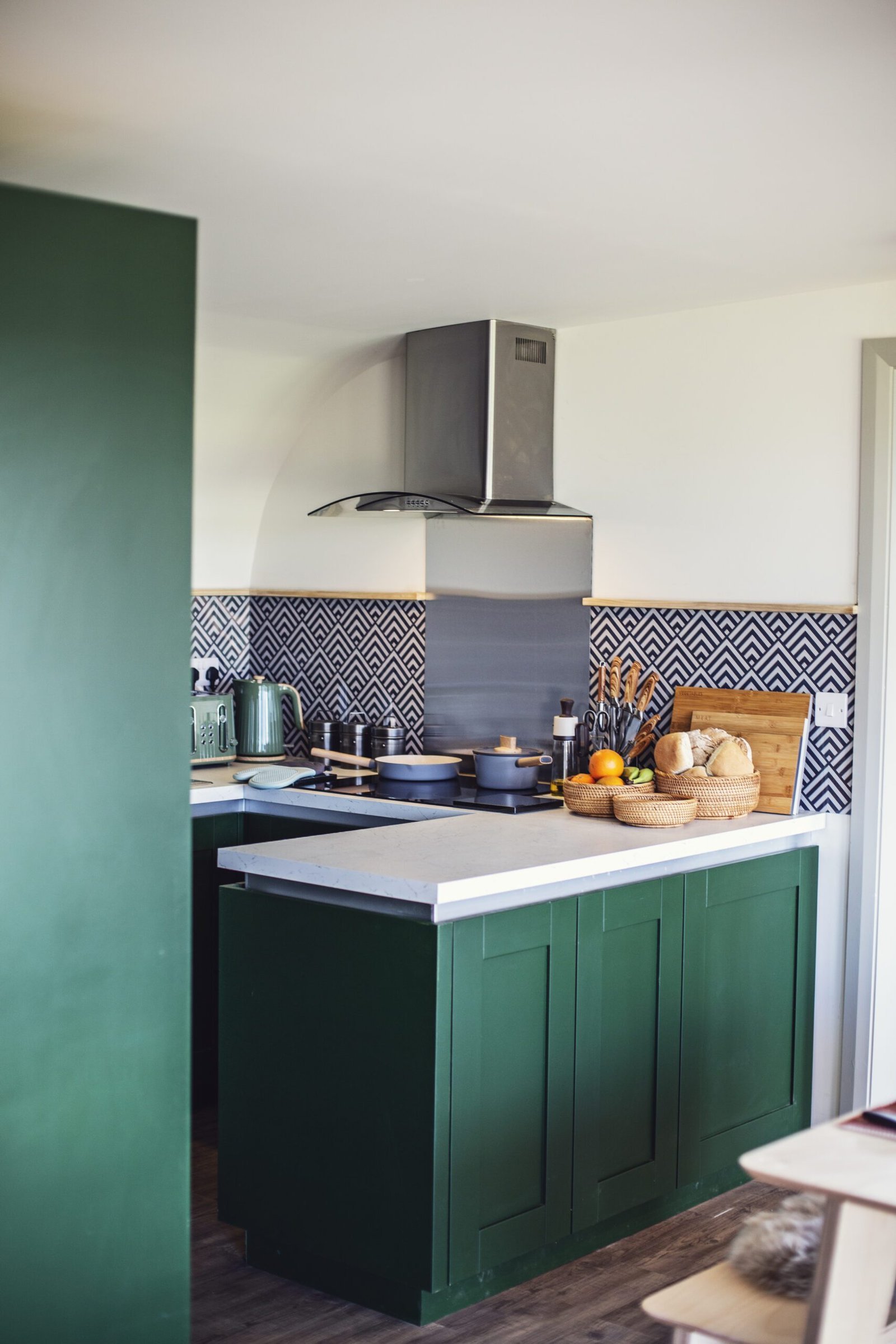 Modern kitchen corner with patterned backsplash and tea, coffee, and sugar jars