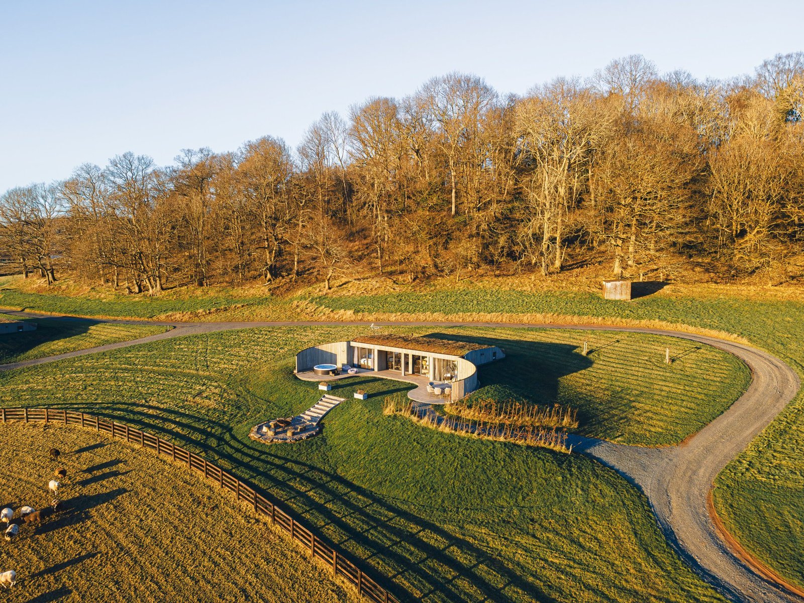 Aerial view of a secluded hillside cabin with hot tub