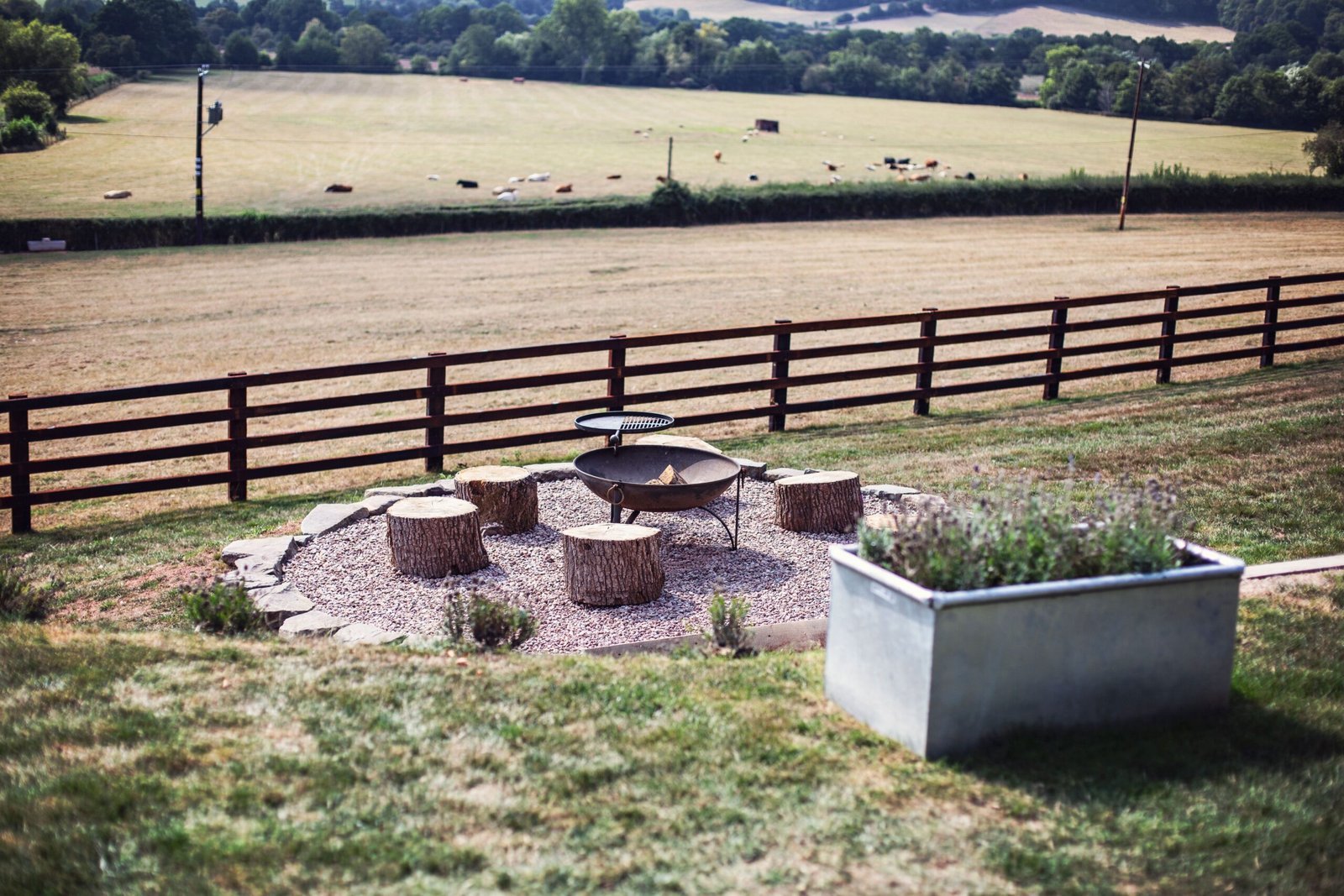 Top Orchard firepit with tree-stump seating and countryside views